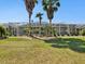 Manicured backyard with palm trees, landscaping, and screened-in pool area at 4423 Gevalia Dr, Brooksville, FL 34604