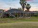 Back of the home with lush landscaping and a spacious screened lanai overlooking a beautiful lawn at 4423 Gevalia Dr, Brooksville, FL 34604
