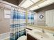 Cozy bathroom featuring a tub, vanity, and shower with blue and white striped curtain at 4423 Gevalia Dr, Brooksville, FL 34604