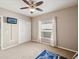 Neutral bedroom features a ceiling fan, carpeted floors, and a window with sheer curtains at 4423 Gevalia Dr, Brooksville, FL 34604