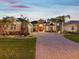 Stunning home featuring lush landscaping and a brick driveway leading to a bright red front door at 4423 Gevalia Dr, Brooksville, FL 34604