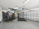 Spacious three car garage with work area, stainless steel refrigerator, and epoxy floor at 4423 Gevalia Dr, Brooksville, FL 34604