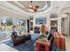 Comfortable living room with elegant tray ceiling, built-in shelving, leather seating and access to the pool area at 4423 Gevalia Dr, Brooksville, FL 34604