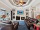Cozy living room featuring a fireplace, custom ceiling and backyard views at 4423 Gevalia Dr, Brooksville, FL 34604