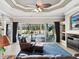 Spacious living room featuring leather seating, blue rug, and sliding glass doors to the outdoor pool area at 4423 Gevalia Dr, Brooksville, FL 34604