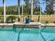 A view of the pool with attached waterfall and tiled accents at 4423 Gevalia Dr, Brooksville, FL 34604