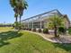 Enclosed screened pool area with palm trees, lush lawn, and meticulous landscaping at 4423 Gevalia Dr, Brooksville, FL 34604