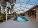 A view of the pool and deck, with covered area with ceiling fan and backyard views at 4423 Gevalia Dr, Brooksville, FL 34604