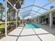 Beautiful pool and lanai surrounded by landscaping, enclosure, and a clear blue sky at 4423 Gevalia Dr, Brooksville, FL 34604