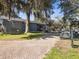 Exterior view of the Pro Shop featuring a brick pathway, golf carts, and mature trees at 4423 Gevalia Dr, Brooksville, FL 34604