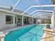 Home's rear elevation with screened in pool, lanai, and landscaping at 4423 Gevalia Dr, Brooksville, FL 34604