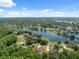 Aerial view of a beautiful neighborhood showcasing homes that surround a serene lake at 4469 Lake In The Woods Dr, Spring Hill, FL 34607