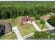 Beautiful home featuring a brick driveway and lush landscaping, set against a dense forest at 4469 Lake In The Woods Dr, Spring Hill, FL 34607