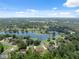 Panoramic neighborhood aerial view, showcasing a serene lake and lush landscape with homes nestled among the trees at 4469 Lake In The Woods Dr, Spring Hill, FL 34607