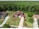 Stunning home with a well-manicured lawn and brick driveway nestled next to a lush green forest backdrop at 4469 Lake In The Woods Dr, Spring Hill, FL 34607