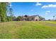 Exterior home view featuring a spacious backyard on a grassy lawn at 4469 Lake In The Woods Dr, Spring Hill, FL 34607