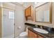 Bathroom with glass shower door, granite countertop, wooden vanity with a mirror and soft lighting at 4469 Lake In The Woods Dr, Spring Hill, FL 34607