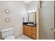 Bathroom with light tile, glass shower door, vanity with granite counters, and wooden cabinets at 4469 Lake In The Woods Dr, Spring Hill, FL 34607