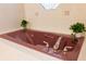 Bathroom featuring a mauve colored jacuzzi tub, tile backsplash, and brushed nickel hardware at 4469 Lake In The Woods Dr, Spring Hill, FL 34607