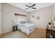 Cozy bedroom with a ceiling fan, neutral walls, side table, and large window at 4469 Lake In The Woods Dr, Spring Hill, FL 34607