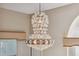 Close up of an elegant chandelier hanging in the dining room with windows on either side at 4469 Lake In The Woods Dr, Spring Hill, FL 34607