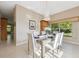Bright dining room featuring a modern chandelier, tile floors, and a view to the living room at 4469 Lake In The Woods Dr, Spring Hill, FL 34607