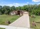 Charming single-Gathering home featuring a lush lawn, landscaped garden beds, and a stylish brick-paved driveway at 4469 Lake In The Woods Dr, Spring Hill, FL 34607