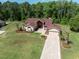Aerial view of a beautifully landscaped single-Gathering home with a lush green lawn and a brick driveway at 4469 Lake In The Woods Dr, Spring Hill, FL 34607