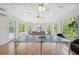 Bright game room with laminate flooring, table tennis, surrounded by large windows, and comfortable seating at 4469 Lake In The Woods Dr, Spring Hill, FL 34607