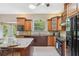 Modern kitchen with wood cabinetry, black appliances, and a center island at 4469 Lake In The Woods Dr, Spring Hill, FL 34607
