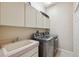 Functional laundry room with modern washer and dryer units and built-in storage cabinets at 4469 Lake In The Woods Dr, Spring Hill, FL 34607