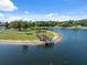A serene aerial view of a pond with a wooden dock, creating a peaceful and inviting waterfront space at 4469 Lake In The Woods Dr, Spring Hill, FL 34607