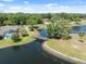 Picturesque aerial shot of a tranquil pond with a charming wooden bridge and lush greenery, adding natural beauty at 4469 Lake In The Woods Dr, Spring Hill, FL 34607