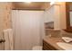 Cozy bathroom with vanity, neutral colored tile, toilet, and shower with curtain at 5031 Essex Ln, Spring Hill, FL 34606