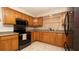 Traditional kitchen with wood cabinets, tile backsplash, and modern black appliances at 5031 Essex Ln, Spring Hill, FL 34606