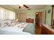 Bright main bedroom featuring a ceiling fan, wood floors, and an ensuite bathroom at 5031 Essex Ln, Spring Hill, FL 34606