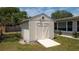 An outdoor storage shed featuring double doors, a small window and a ramp on a grassy lawn at 5031 Essex Ln, Spring Hill, FL 34606