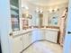 Dual sink bathroom with patterned wallpaper, cabinetry, and excellent lighting at 585 Sky Harbor Dr # 219, Clearwater, FL 33759