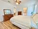 Bedroom with light hardwood floors, ceiling fan, dresser, and Primary bathroom access at 585 Sky Harbor Dr # 219, Clearwater, FL 33759