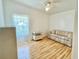 Bedroom with hardwood floors, ceiling fan, and horizontally striped sofa at 585 Sky Harbor Dr # 219, Clearwater, FL 33759