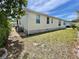 Exterior of home with light-yellow siding, brick foundation, and well-maintained lawn at 585 Sky Harbor Dr # 219, Clearwater, FL 33759