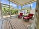 Screened-in porch with red cushioned chairs and privacy from surrounding trees at 585 Sky Harbor Dr # 219, Clearwater, FL 33759