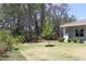 The spacious backyard features lush greenery, a young tree, and surrounding wooded areas at 6063 Dusk Rose Ln, Brooksville, FL 34601