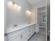 Bathroom featuring double sinks, white cabinets and drawers, modern fixtures and lighting at 6063 Dusk Rose Ln, Brooksville, FL 34601