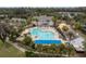 An aerial view of the expansive community pool and hot tub, with surrounding facilities and lush landscaping at 6063 Dusk Rose Ln, Brooksville, FL 34601
