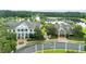 Aerial view of the property featuring a white facade, large windows, manicured landscaping, and a nearby lake at 6063 Dusk Rose Ln, Brooksville, FL 34601