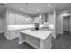 Bright kitchen boasts white cabinets, large island, modern appliances, and stylish pendant lighting at 6063 Dusk Rose Ln, Brooksville, FL 34601