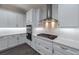 Modern kitchen with white cabinets, stainless steel appliances, and stylish range hood at 6063 Dusk Rose Ln, Brooksville, FL 34601