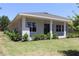 This home's rear exterior features a covered patio, windows, and is surrounded by lush green lawns at 6063 Dusk Rose Ln, Brooksville, FL 34601