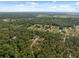 An aerial view of the home and acreage showcases surrounding lush green space at 6080 Dexter Ln, Brooksville, FL 34602